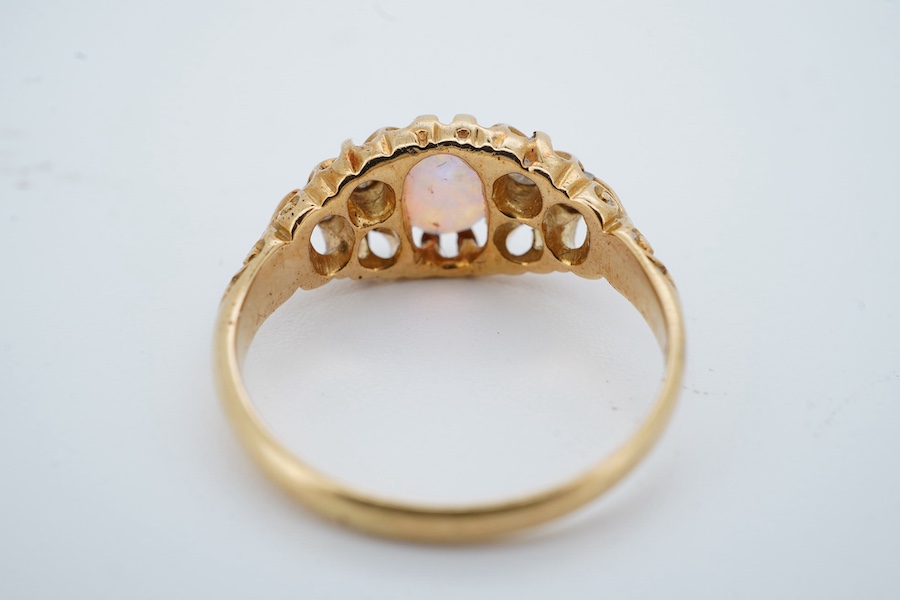 A late Victorian 18ct gold and oval white opal ring with six stone diamond set shoulders, size J, hallmarked for Birmingham, 1899, gross weight 2.5 grams. Condition - poor to fair